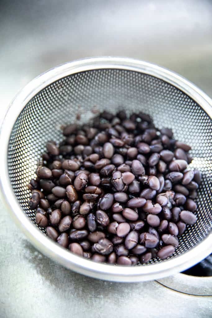 Cooked black beans drained for Thai banana sticky rice.