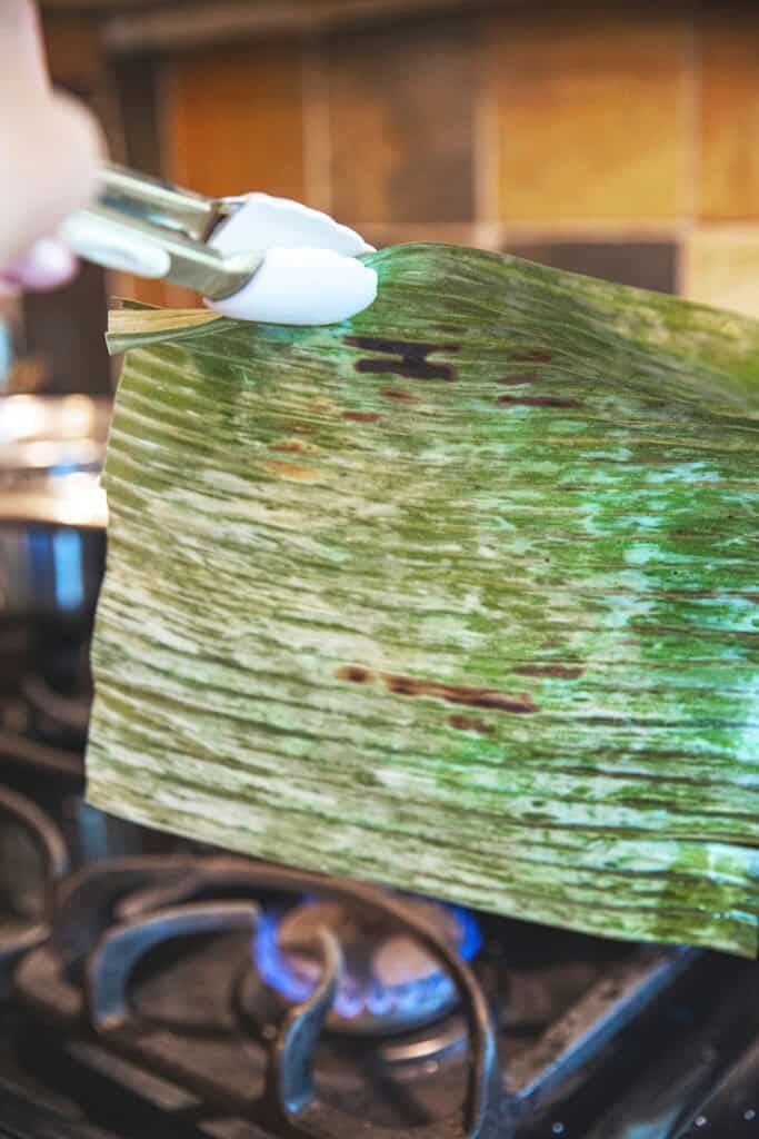 Frozen banana leaf softened over low flame before wrapping.