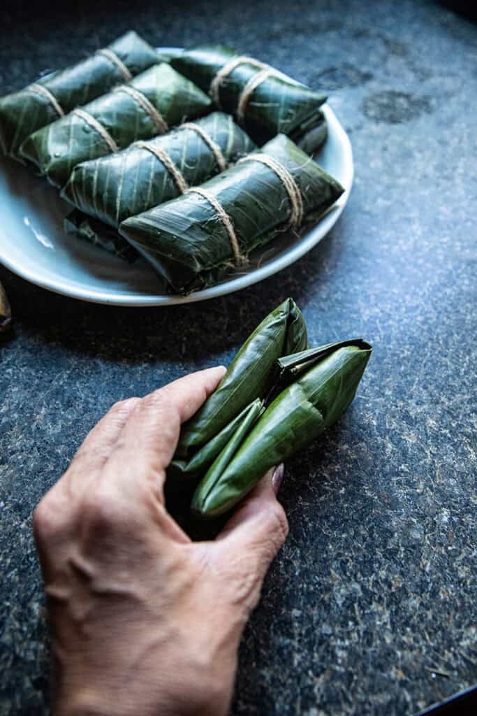 Homemade Khao Tom Mud wrapped in pairs in banana leaves.