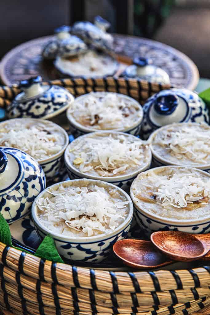 Khanom Kluay steamed banana desserts served in Thai ceramic cups.